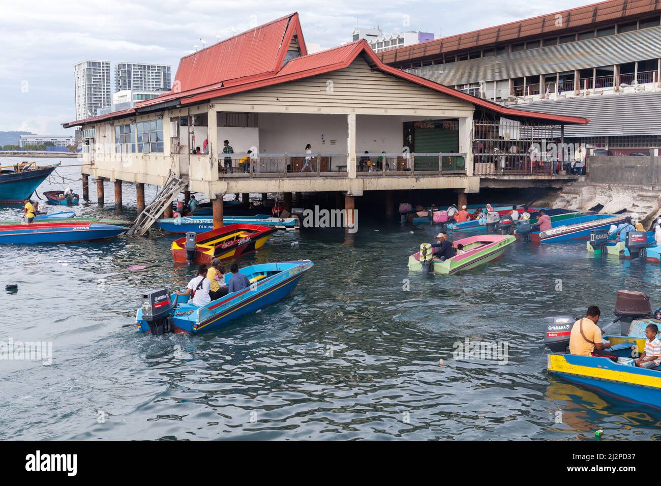 Kota Kinabalu, Malesia - 23 marzo 2019: Barche a motore con passeggeri sono vicino al mercato del pesce KK in una giornata di sole, a buon mercato mezzi di trasporto pubblico tra islan Foto Stock