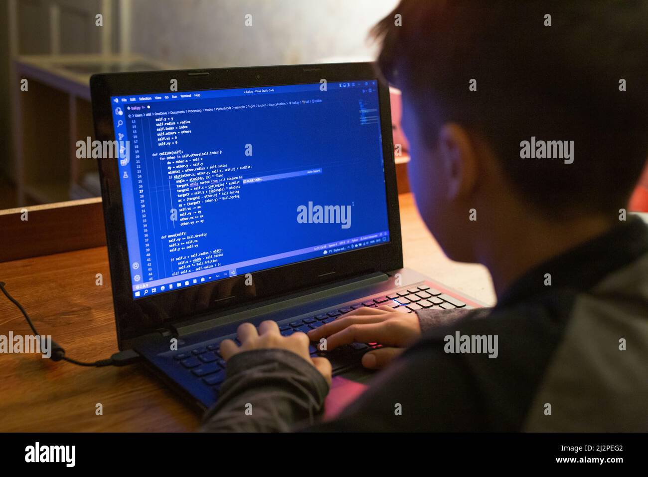 Giovane ragazzino nerd che codifica sul portatile di notte Foto Stock