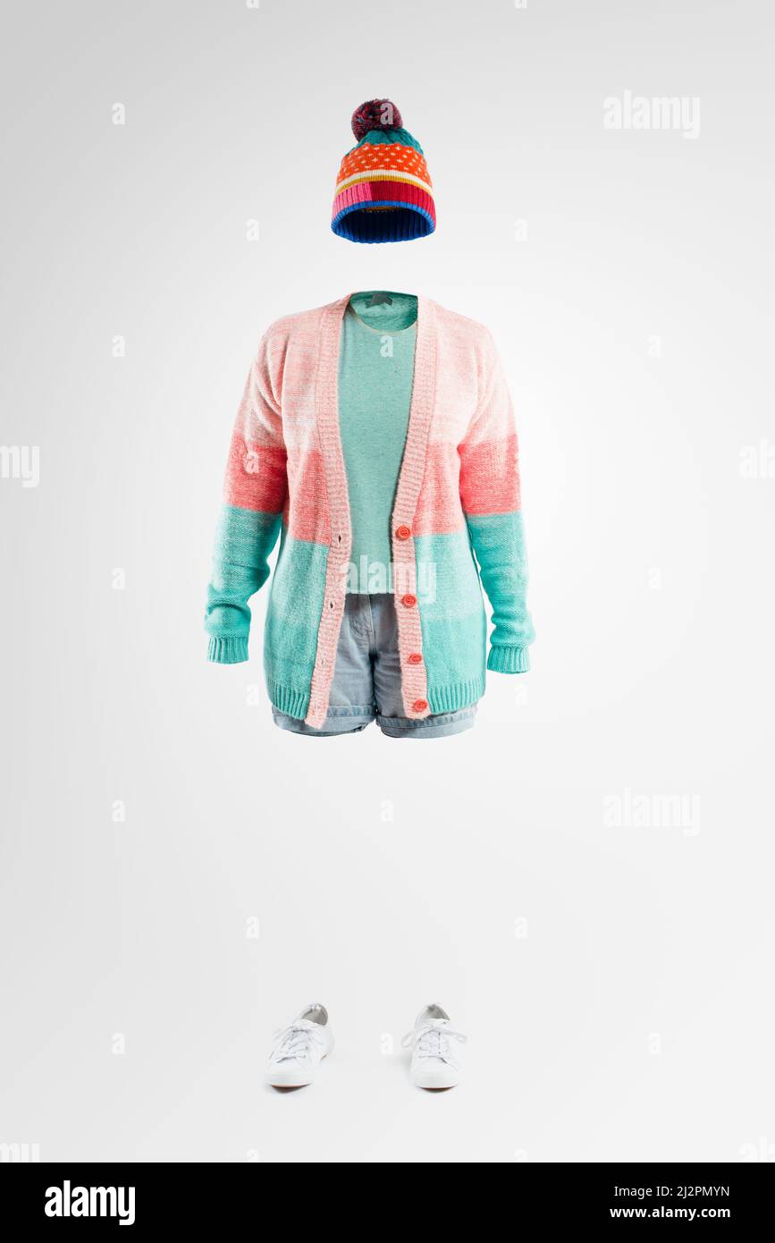 Come sapete im non realmente qui. Studio girato di una donna invisibile indossando abbigliamento invernale in piedi su uno sfondo grigio. Foto Stock