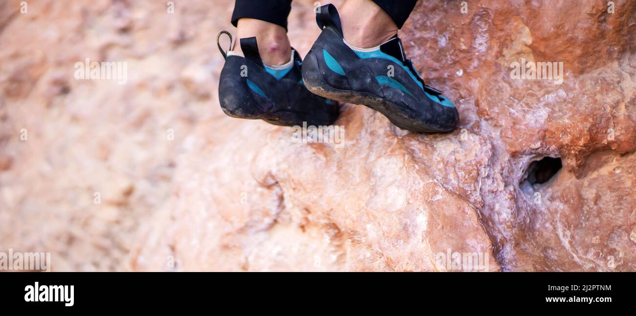 Piedi con scarpe da arrampicata sul primo piano rocce. Foto Stock