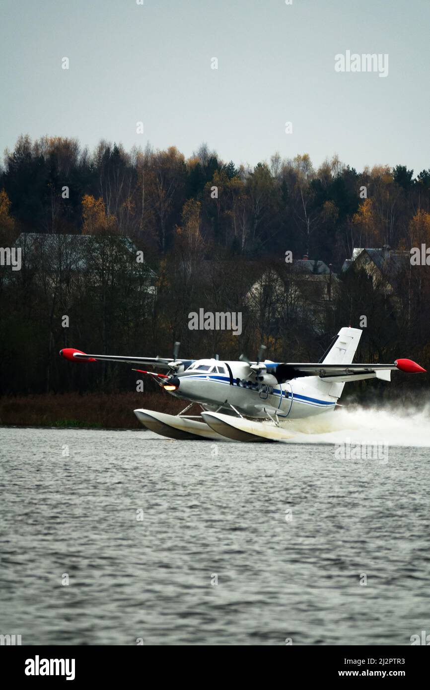 Il idrovolante a due motori un idrovolante sorge dall'acqua, dal lago forestale, terra settentrionale. Idrovolante di servizio Foto Stock