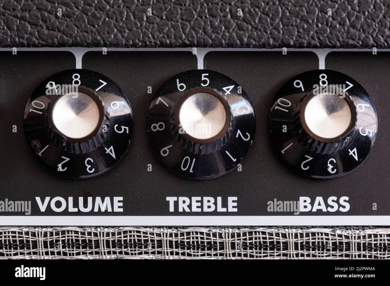 dettaglio delle manopole di controllo del volume, degli alti e dei bassi di un amplificatore per chitarra, quadranti di equalizzazione ravvicinati, messa a fuoco selettiva orizzontale Foto Stock