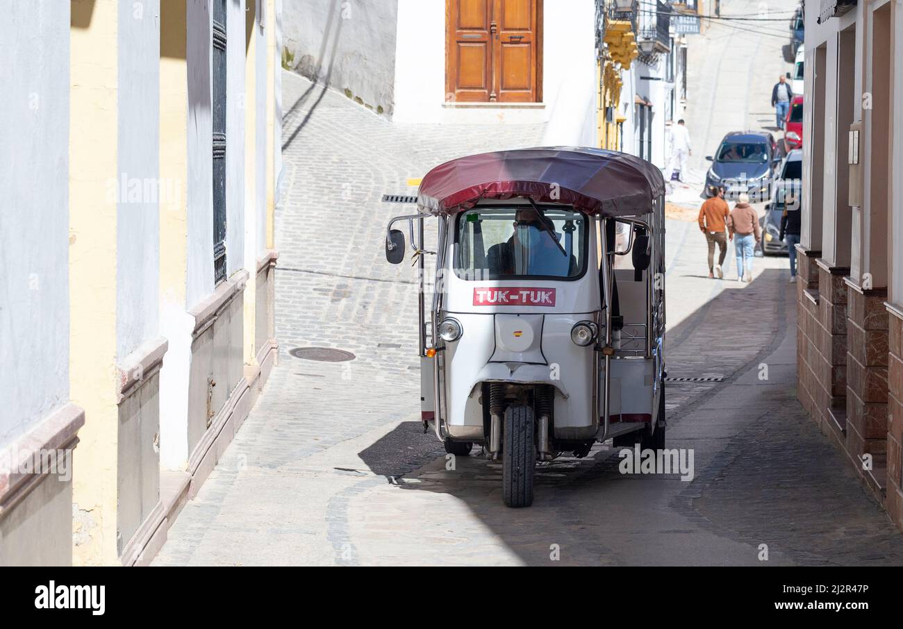 Un risciò automatico Tuk-Tuk percorre le strette strade di Setenil de las Bodegas Foto Stock