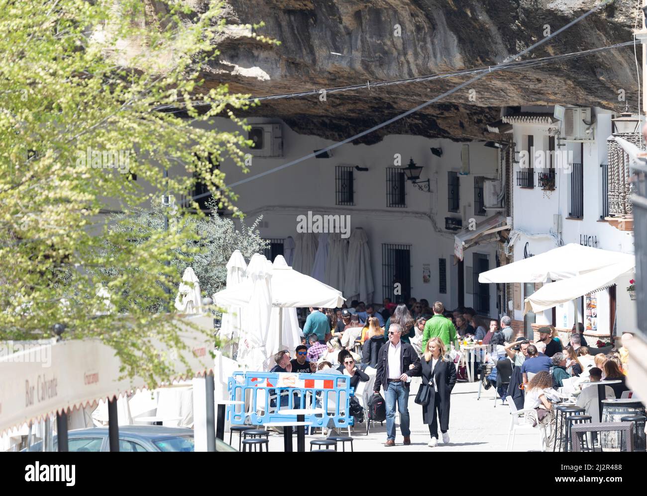 I turisti visitano i bar e i ristoranti scavati nelle grotte di montagna a Setenil de las Bodegas Foto Stock