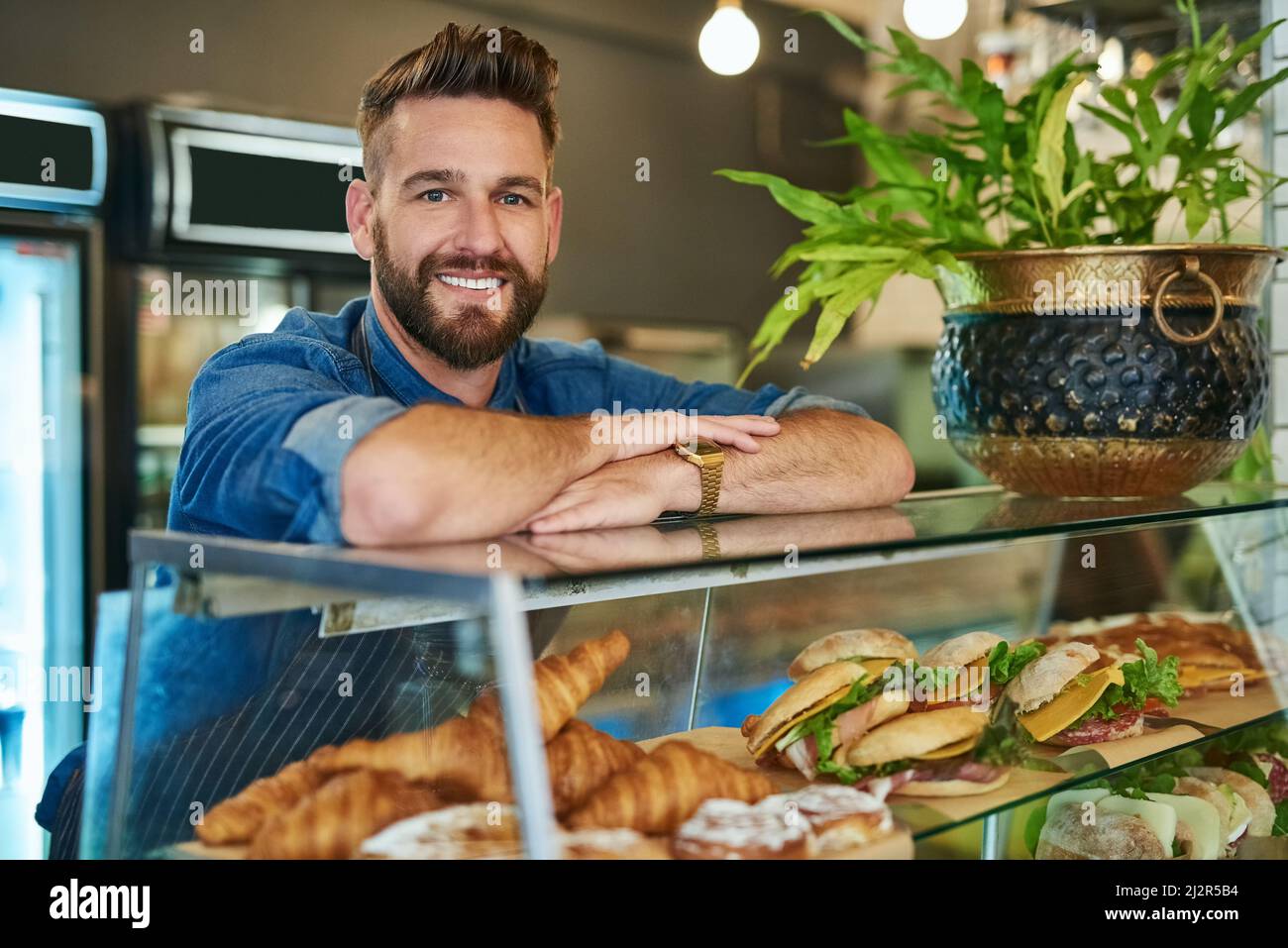 Non cercate oltre per i pasti freschi e convenienti. Ritratto di un orgoglioso imprenditore che lavora nel suo negozio. Foto Stock