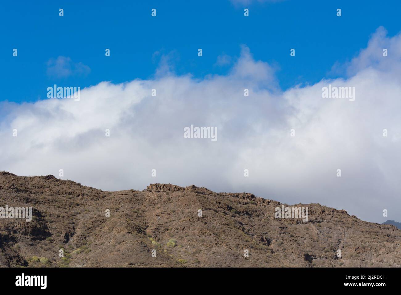 Montagne sulla costa tra Puerto de Mogan e Puerto Rico. Strati di roccia vulcanica. Foto Stock