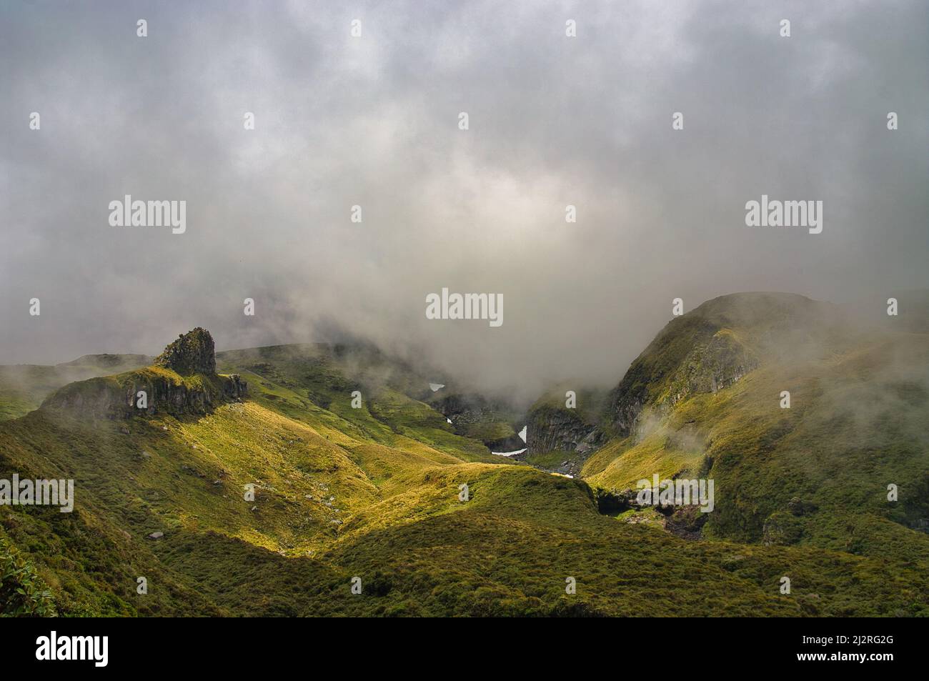 Le aspre gole alpine e le fessure del Castello di Humphries sul vulcano Monte Taranaki (Nuova Zelanda) avvolti da nuvole minacciose. Foto Stock