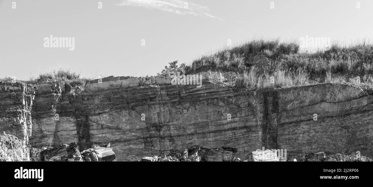 Roccia che viene scavata in una cava ad uso industriale nella costruzione di strade ecc. strati nella roccia visibile. Foto Stock