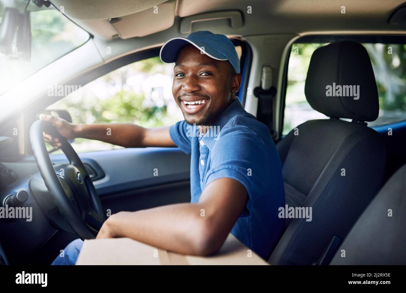 Im a modo mio. Ritratto di un giovane postale che lavora seduto in macchina durante una consegna. Foto Stock