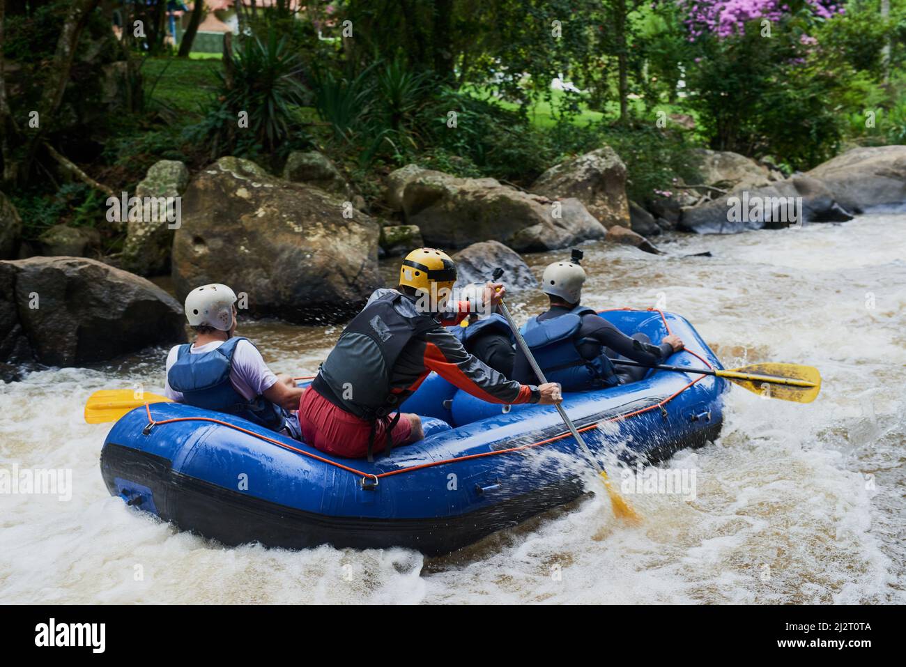 La natura offrirà alcune delle migliori avventure. Shot di un gruppo di giovani amici maschi rafting. Foto Stock