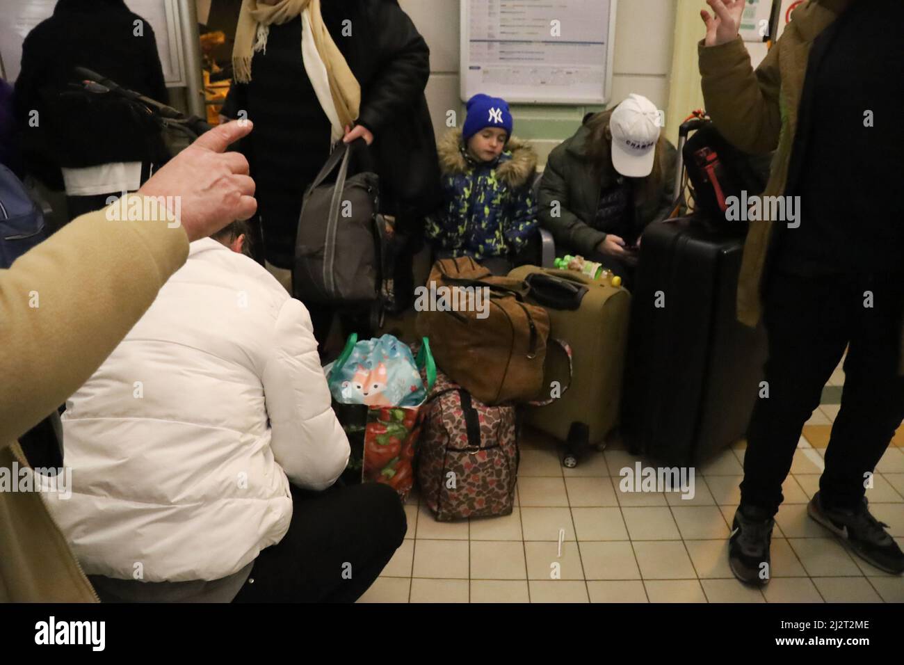 Przemysl, Polonia. 3rd Apr 2022. I rifugiati ucraini che fuggono dal terrore di Putin arrivano alla stazione ferroviaria di Przemysl, dopo aver attraversato il confine tra Ucraina e Polonia. Qui una piccola ragazza Ucraina in un cappello Yankees di New York si spegne, vicino all'ora di mezzanotte, mentre altri rifugiati e volontari trambustano intorno a.. Credit: ZUMA Press, Inc./Alamy Live News Foto Stock