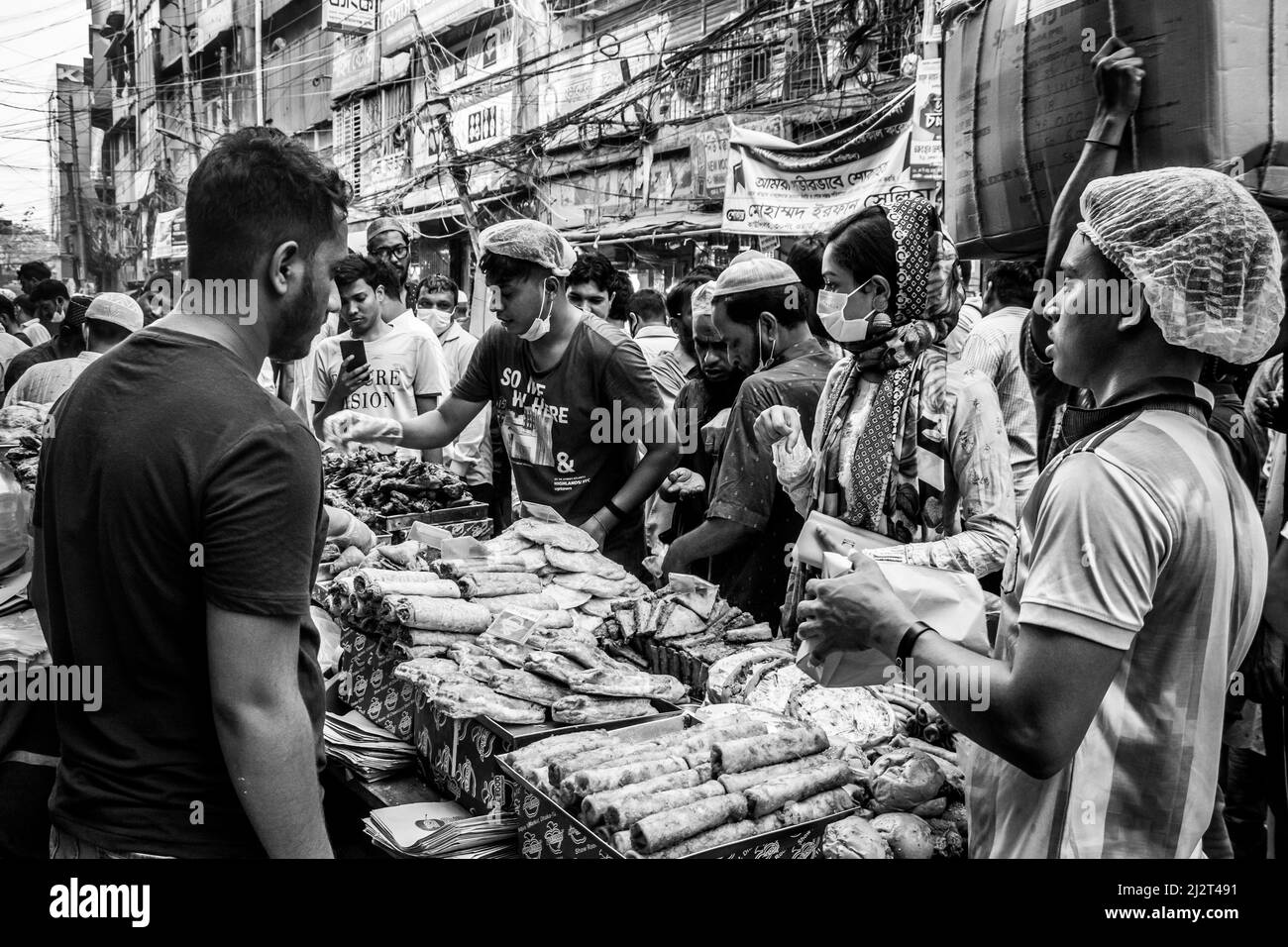 La popolazione locale del Bangladesh vende articoli di Iftar a Chawkbazar nella capitale Dhaka, Bangladesh, il primo giorno del mese musulmano di digiuno Holly Ramadan Foto Stock