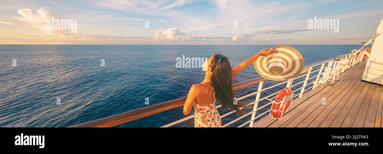 Happy crociera donna rilassante sul ponte sensazione di guardare il tramonto dalla nave in vacanza caraibica di viaggio. Bandiera panoramica di mare e barca Foto Stock
