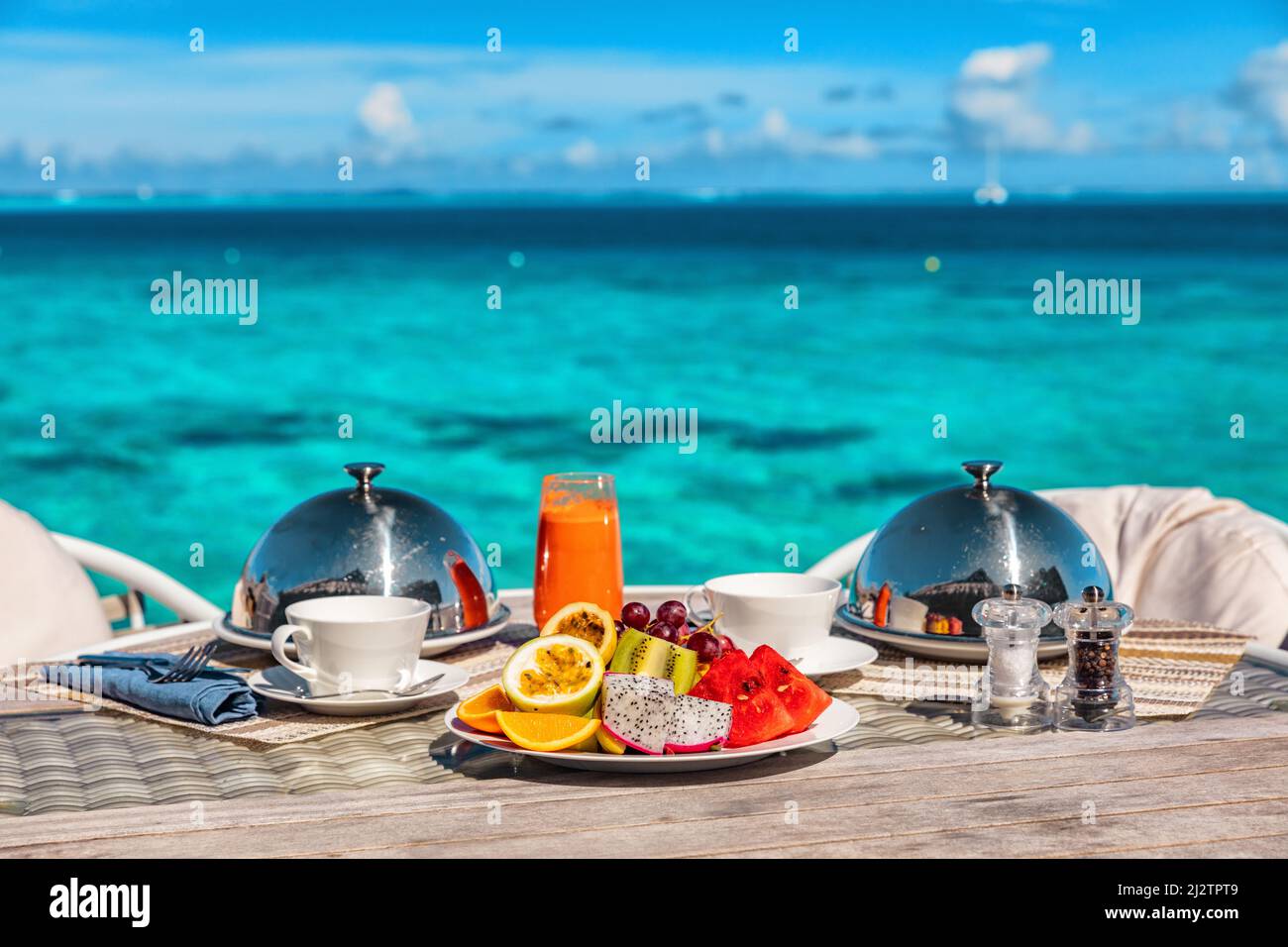 Colazione per le vacanze in una camera di lusso con vista sull'oceano. Romantica vacanza in luna di miele alle Maldive o Tahiti. Presentazione di due piatti, frutta Foto Stock