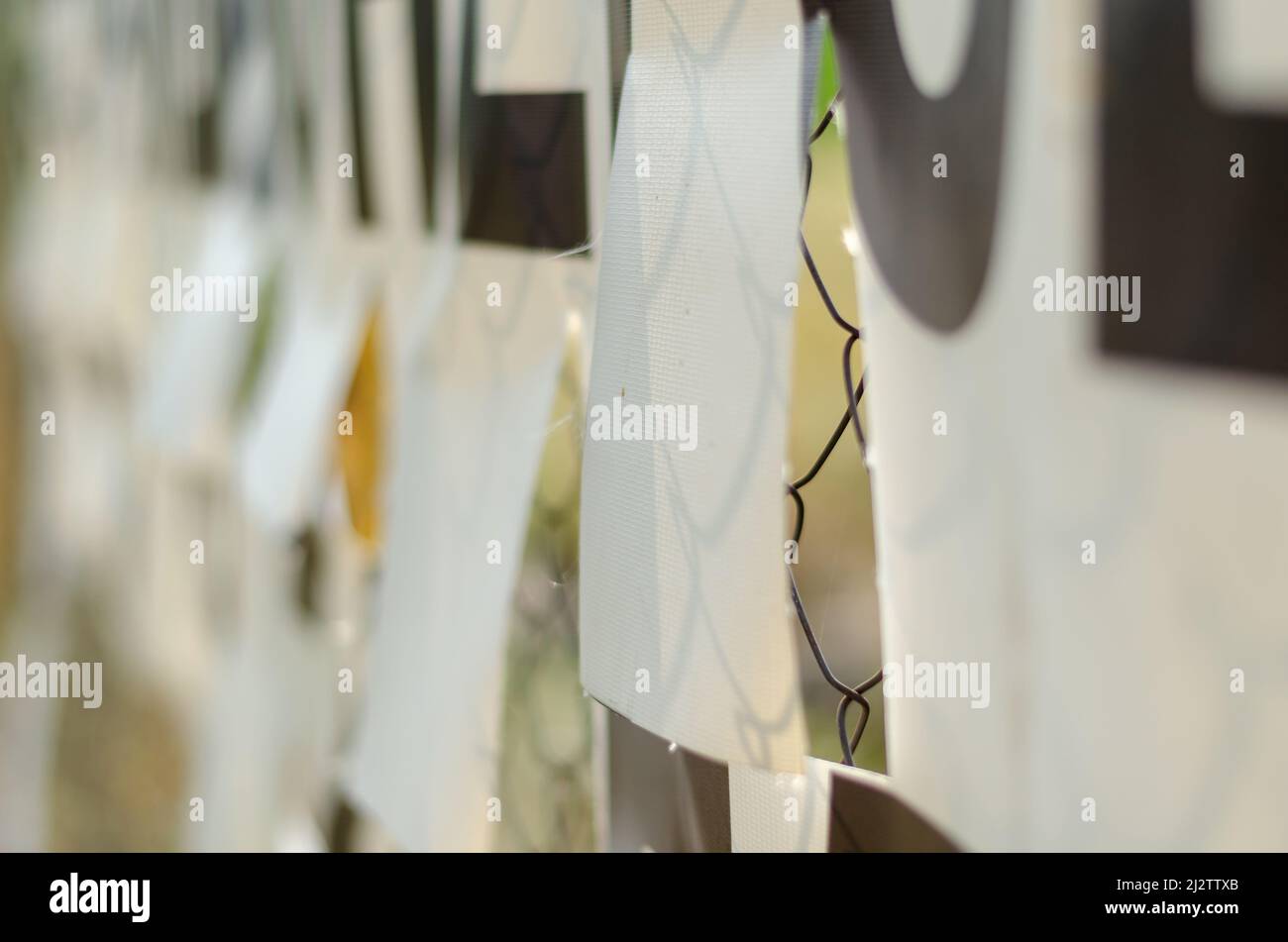 Il banner è attaccato alla griglia di Rabbitz. Striscione bianco con fori perforati. Fori speciali per ridurre la resistenza al flusso del vento. Foto Stock