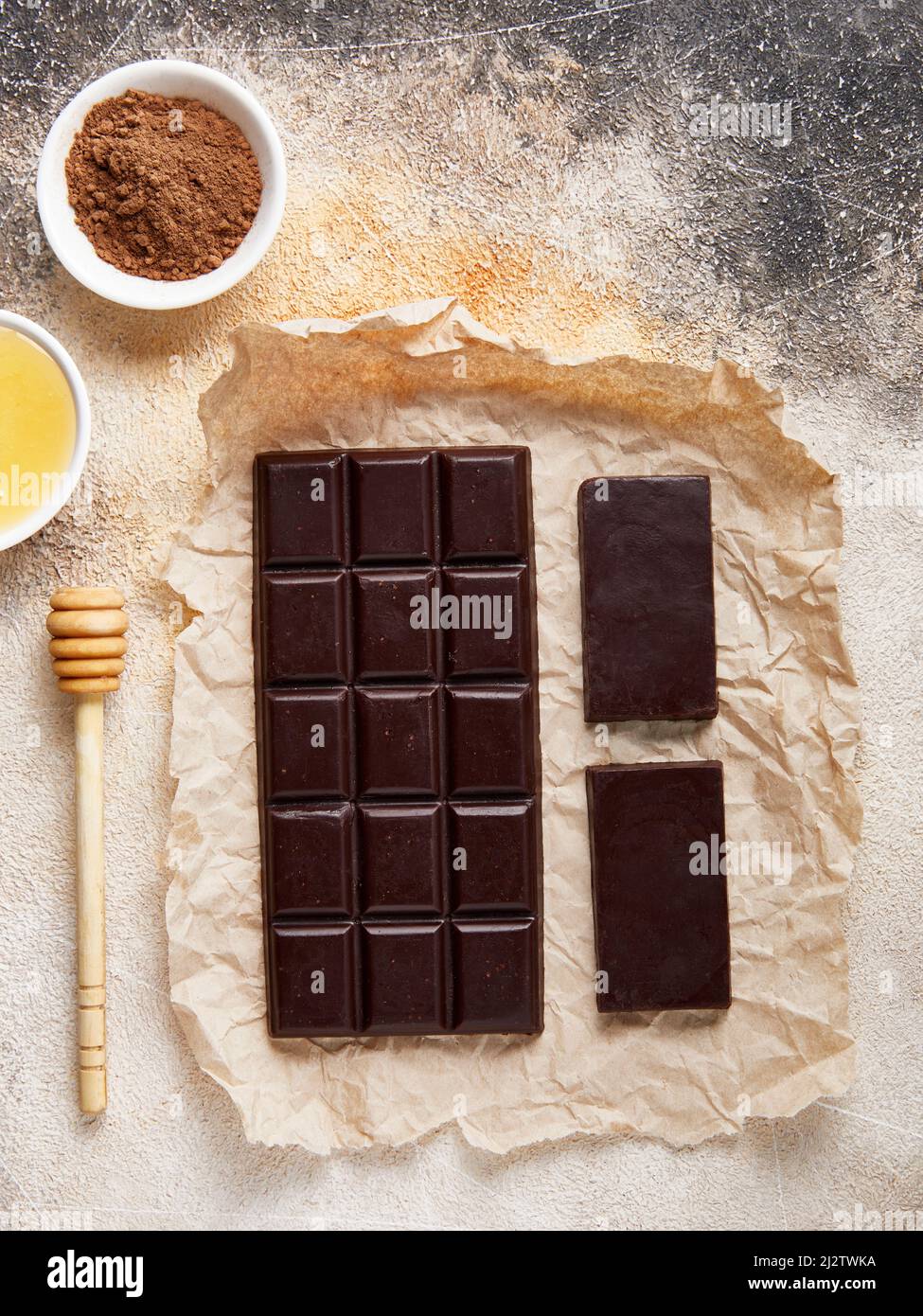Sano zucchero libero cioccolato fondente fatto in casa con cacao e miele su carta artigianale. Bar grandi e piccoli Foto Stock