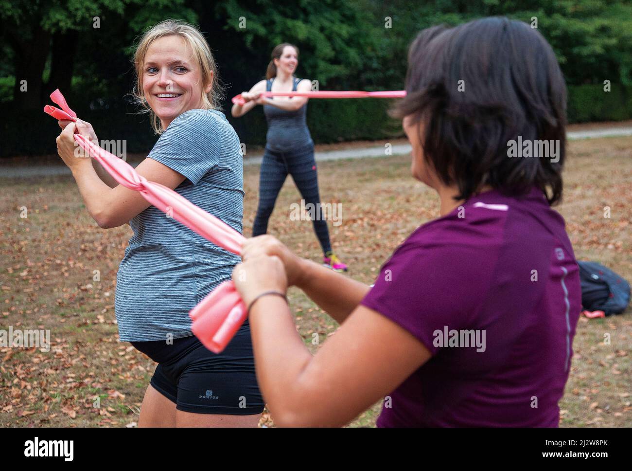 Paesi Bassi, Arnhem - donne incinte bootcamp in un parco. Formatore di 'Mom in Balance' che istruisce una delle parti di addestramento del bootcamp. Foto Stock