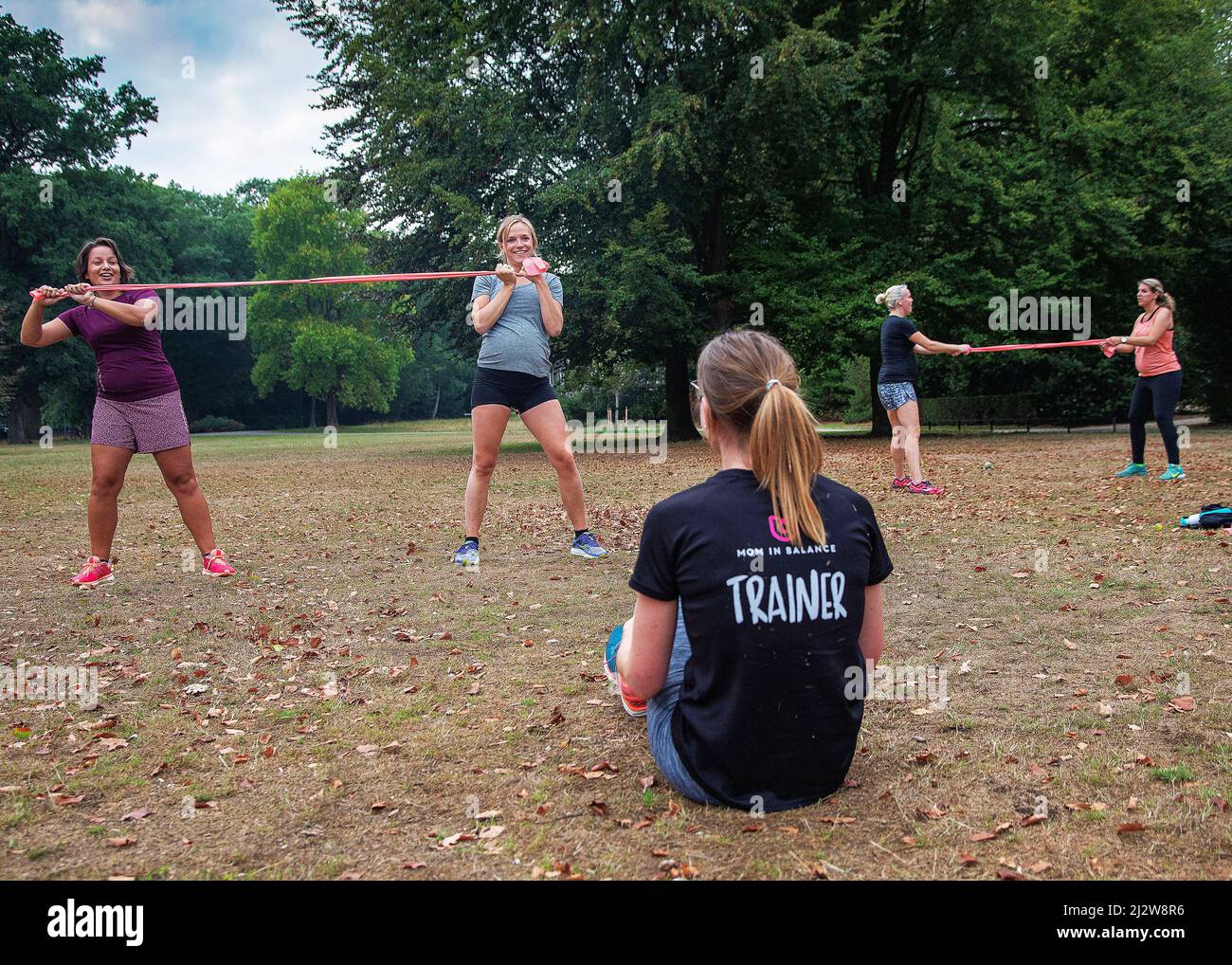 Paesi Bassi, Arnhem - donne incinte bootcamp in un parco. Formatore di 'Mom in Balance' che istruisce una delle parti di addestramento del bootcamp. Foto Stock