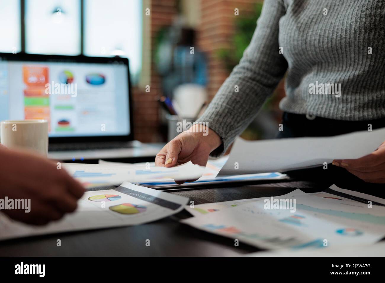 Primo piano delle donne d'affari che tengono i documenti di affari con i grafici di gestione su esso che lavora alla strategia dell'azienda nell'ufficio di startup. Idee di brainstorming del team di marketing per il progetto di partnership Foto Stock