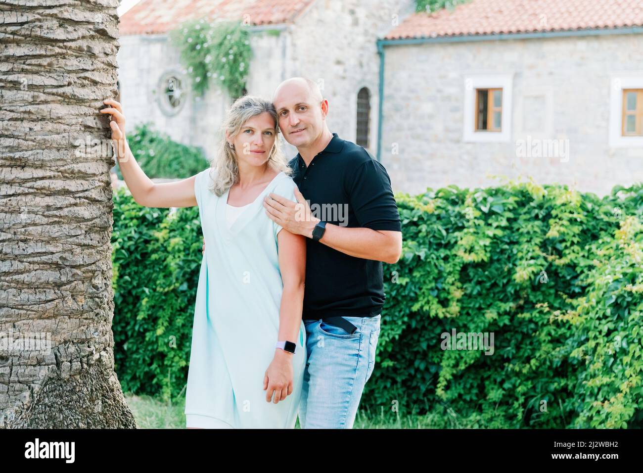 Giovane coppia - uomo e donna in piedi in un bellissimo parco nelle vicinanze. L'uomo abbraccia la donna per la spalla Foto Stock
