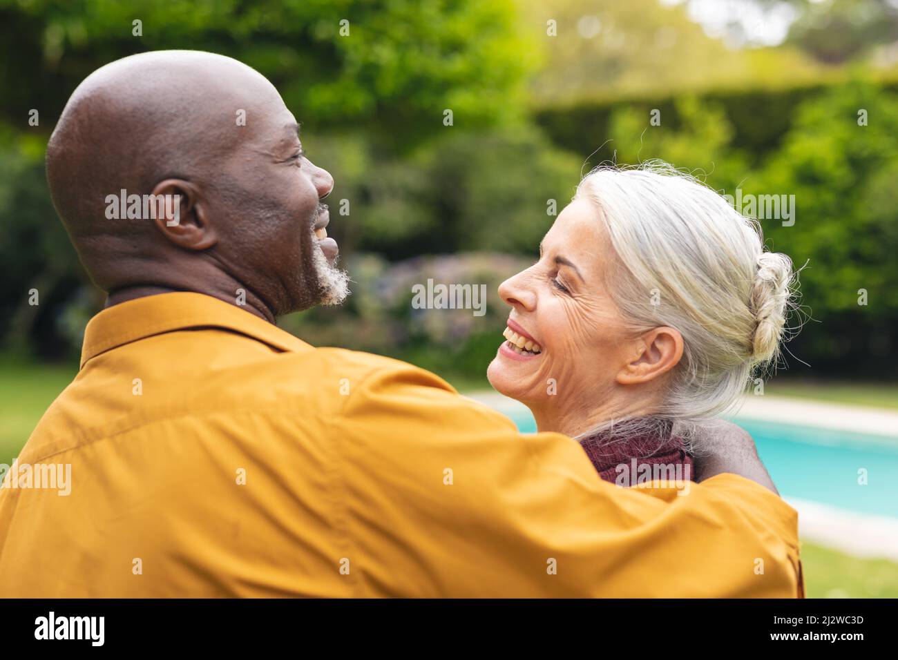 Allegra coppia multirazziale anziana che trascorre il tempo libero insieme in cortile Foto Stock