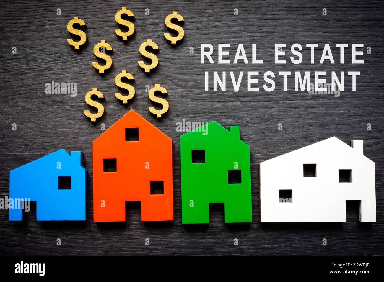 Concetto di investimento immobiliare. Modelli di casa e segni del dollaro. Foto Stock