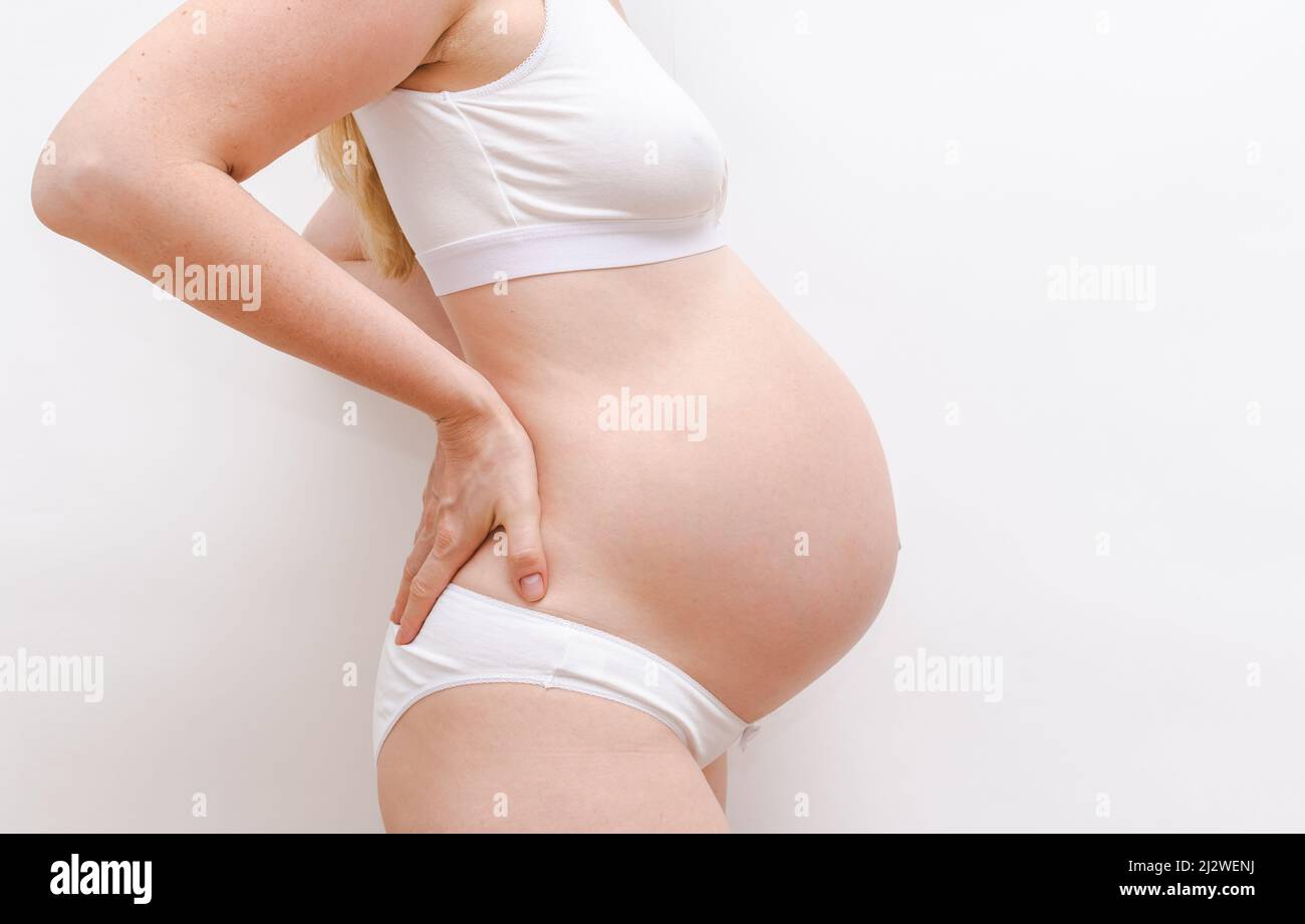 ventre di una donna incinta su sfondo bianco Foto Stock