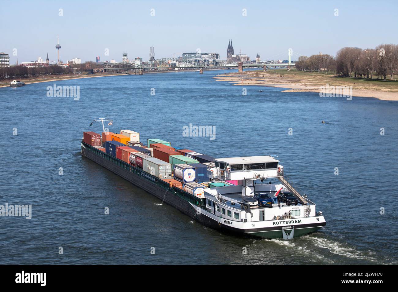 Nave container sul Reno in direzione nord, sullo sfondo le Crane Houses al porto di Rheinau e la cattedrale, Colonia, Germania. Containa Foto Stock