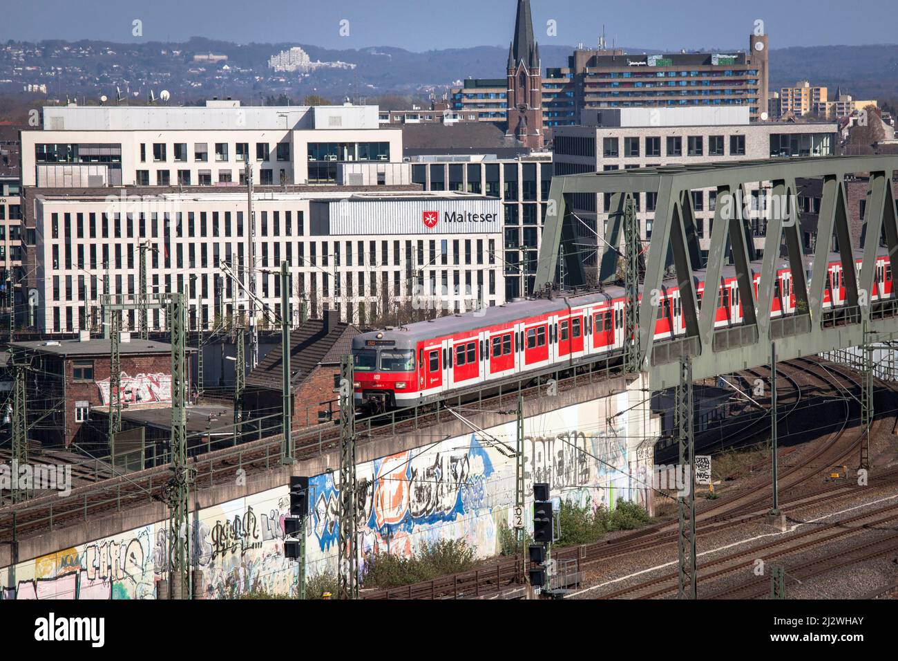 Treno locale S-Bahn Rhein-Ruhr nel quartiere Deutz, sullo sfondo la sede del Malteser Hilfdienst (MHD), Colonia, Germania. Zug d Foto Stock