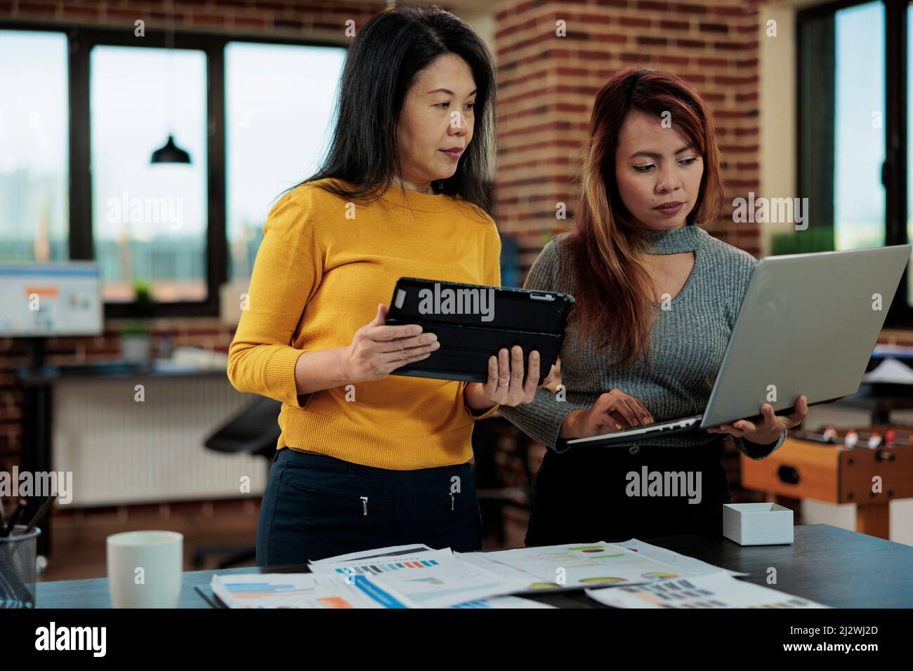 I responsabili esecutivi confrontano le statistiche di marketing di quest'anno con l'anno scorso lavorando alla strategia aziendale per aumentare i ricavi. Team di gestione che discute idee di partnership aziendale in startup Office Foto Stock