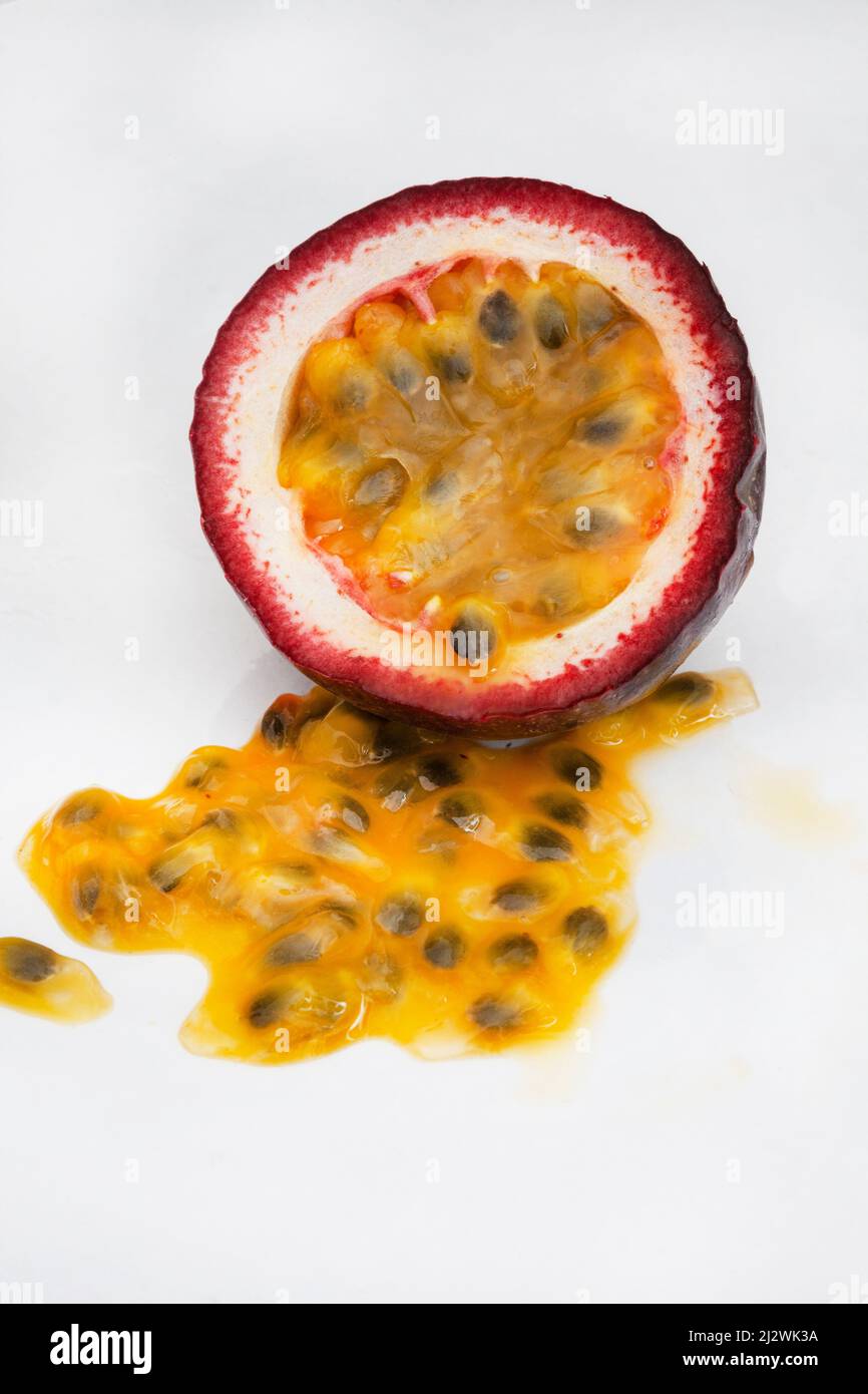 Granadilla o frutto della passione, tagliato aperto con polpa su sfondo bianco Foto Stock