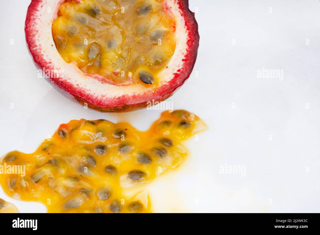 Granadilla o frutto della passione, tagliato aperto con polpa su sfondo bianco Foto Stock