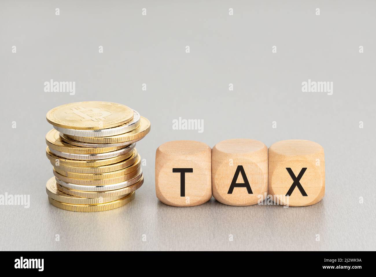 Concetto di tassa di criptovaluta. Monete cripto impilate e blocchi di legno con testo. Spazio di copia Foto Stock