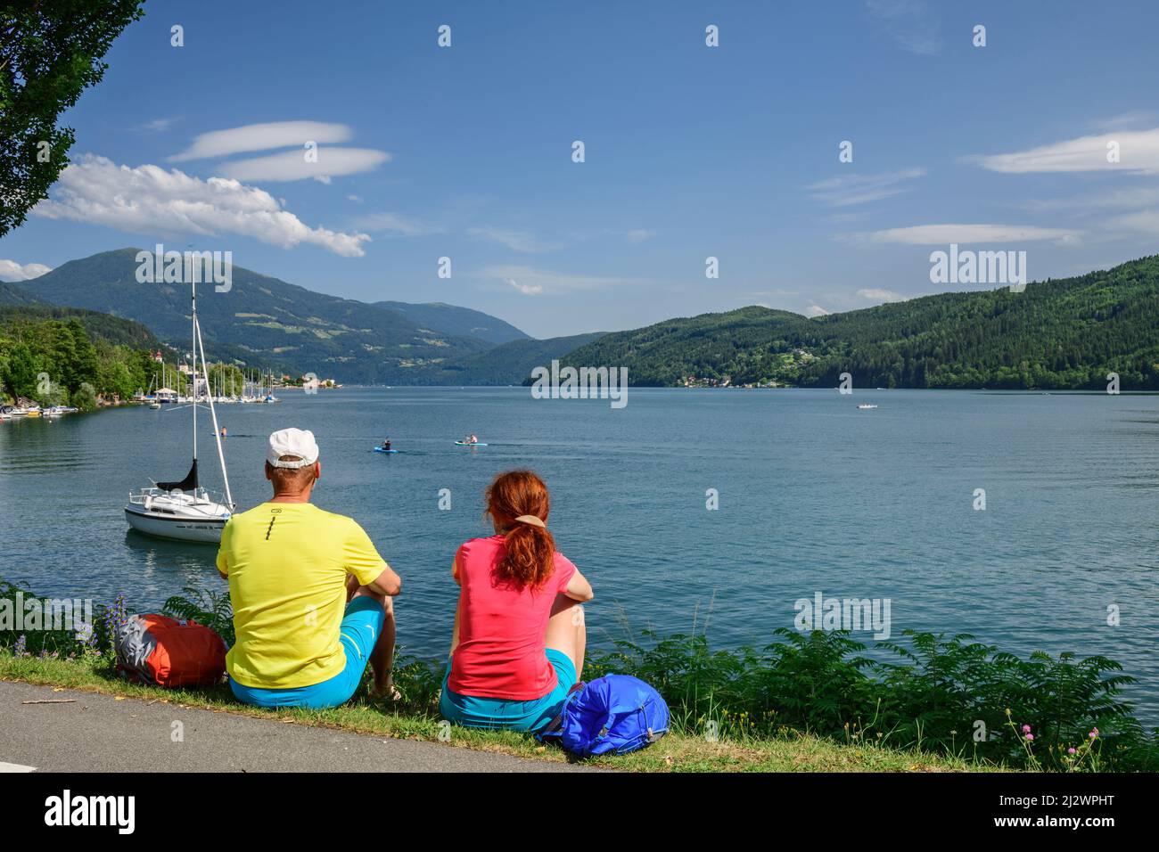 Uomo e donna durante le escursioni, seduto sulle rive del Lago Millstatt, Lago Millstatt, Nockberge Trail, Carinzia, Austria Foto Stock