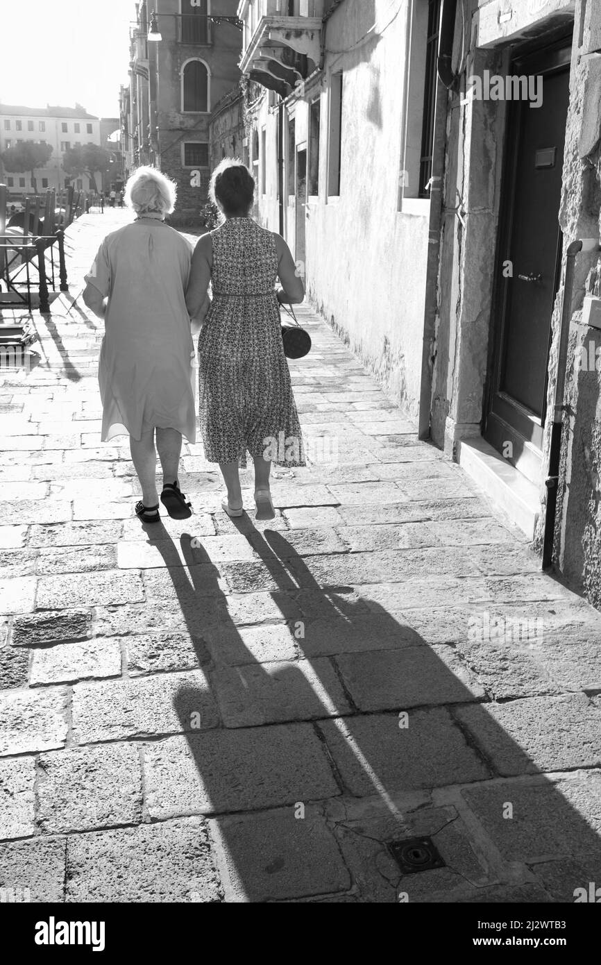 Donne anziane che camminano braccio in braccio, vista posteriore a Venezia, Veneto, Italia, Europa Foto Stock
