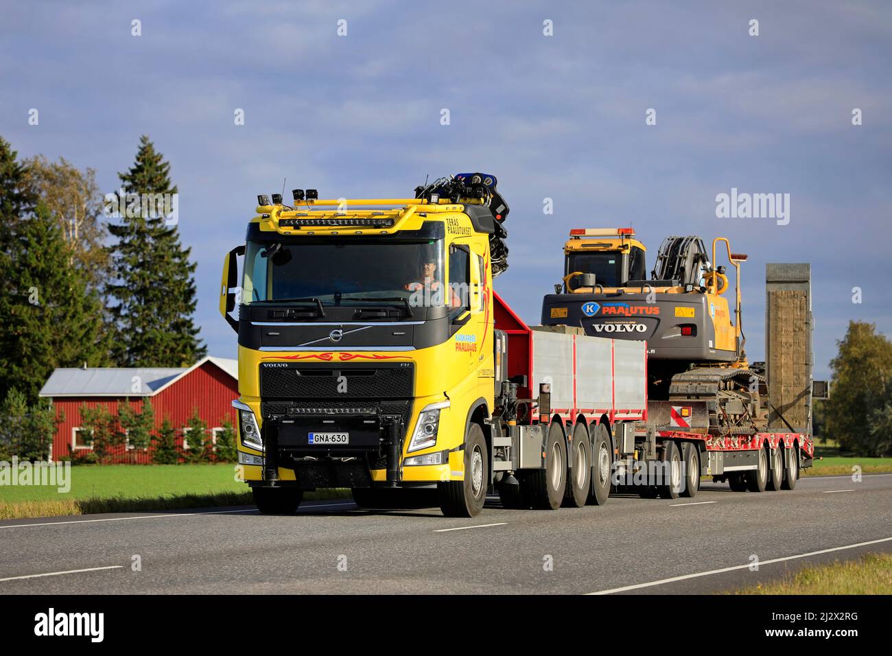 Volvo FH autocarro giallo personalizzato di Kankareen Paalutus Oy trasporta l'escavatore Volvo in una serata autunnale soleggiata. Loimaa, Finlandia. Settembre 18, 2020. Foto Stock