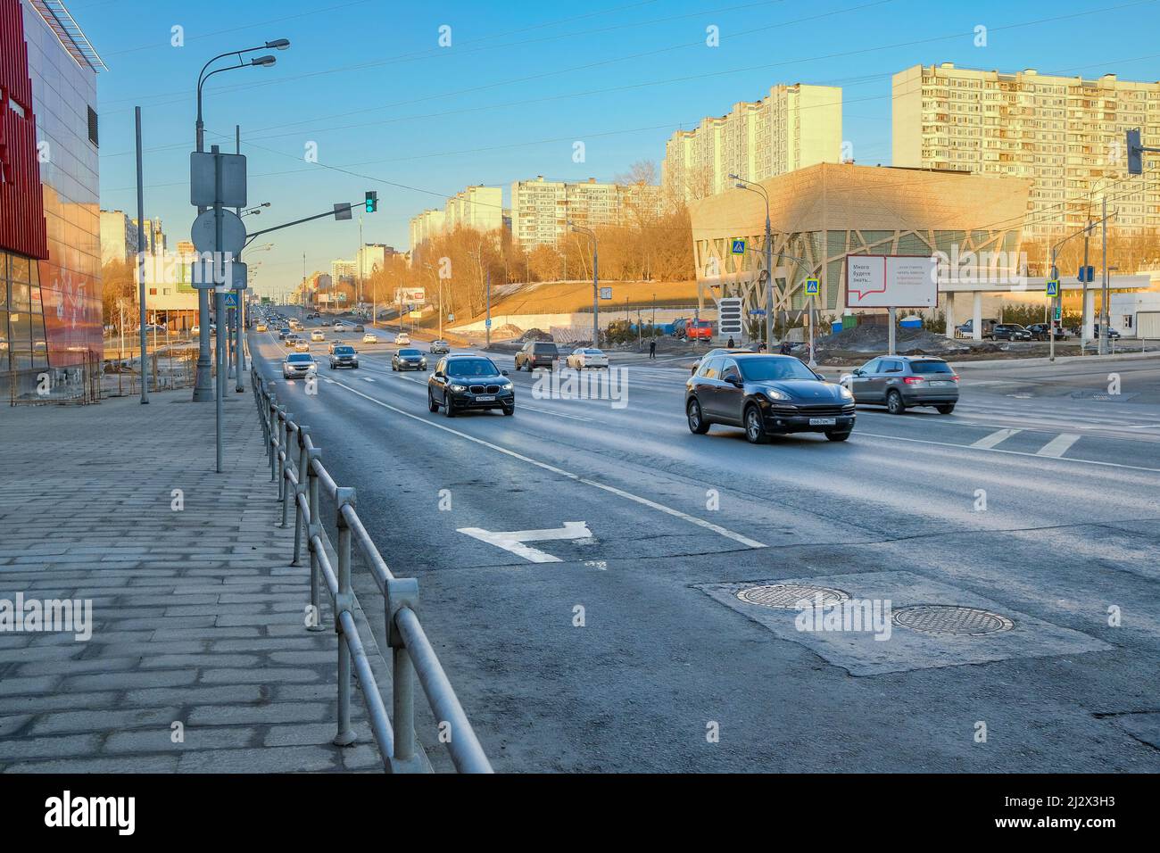 Mosca. Russia. Marzo 22, 2022. Vista delle auto che si muovono lungo la strada della città. Una strada cittadina in primavera sotto un cielo blu nuvoloso. Foto Stock