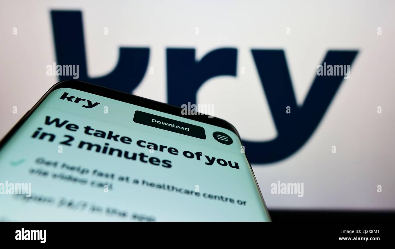 Smartphone con sito web della società sanitaria svedese Kry International AB sullo schermo davanti al logo. Mettere a fuoco sulla parte superiore sinistra del display del telefono. Foto Stock