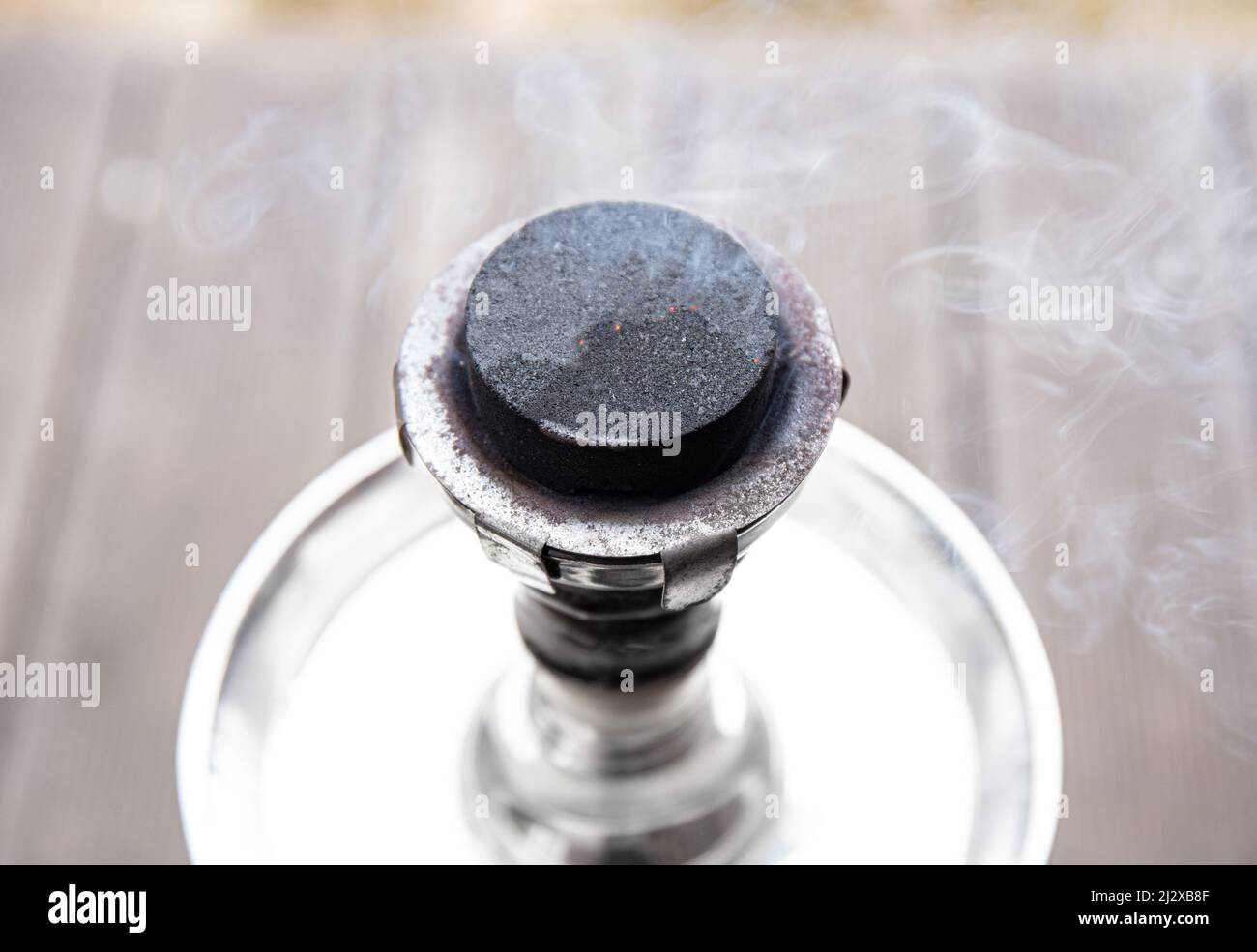 Primo piano di vista di Hookah shisha waterpipe carbone che brucia, scintille volare, fumo in arrivo. Foto Stock