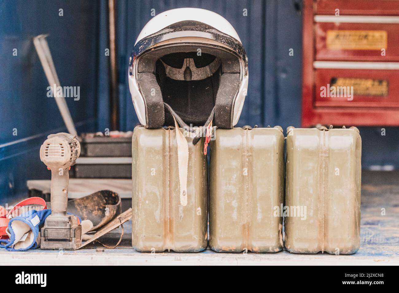 Un casco, serbatoi, un cacciavite pneumatico e guanti all'interno di un camion. Concetto di motorsport, automotive. Spazio di copia. Foto Stock
