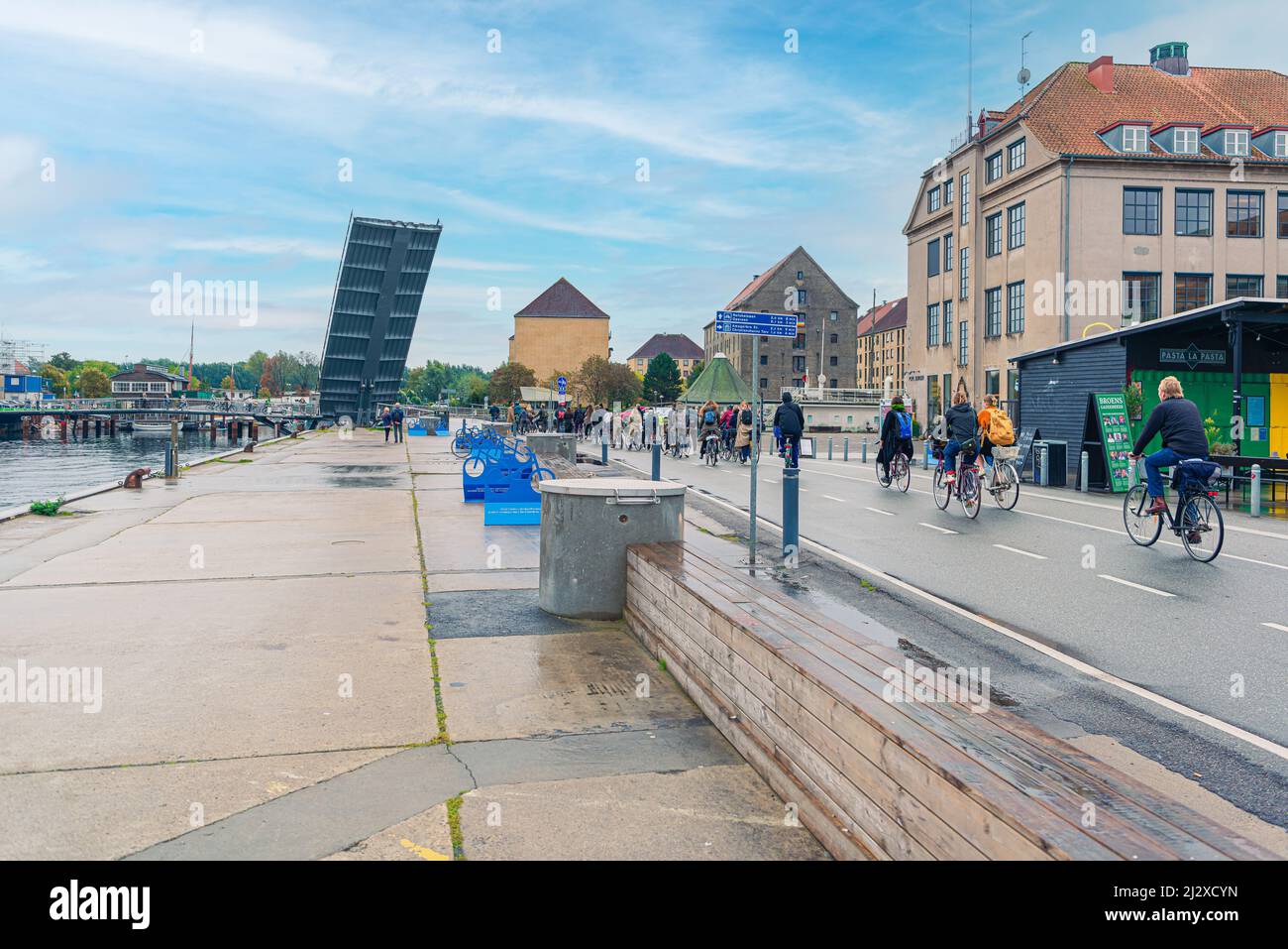 Una grande fila di ciclisti si trova vicino ai passaggi sopraelevati del Butterfly 3-Way Bridge, un ponte leggero per pedoni e ciclisti a copenhagen, Danimarca Foto Stock