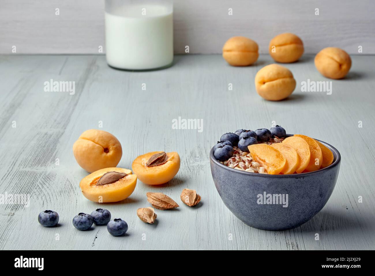 Fiocchi d'avena a grani interi con semi di lino, fette di albicocca e mirtilli Foto Stock