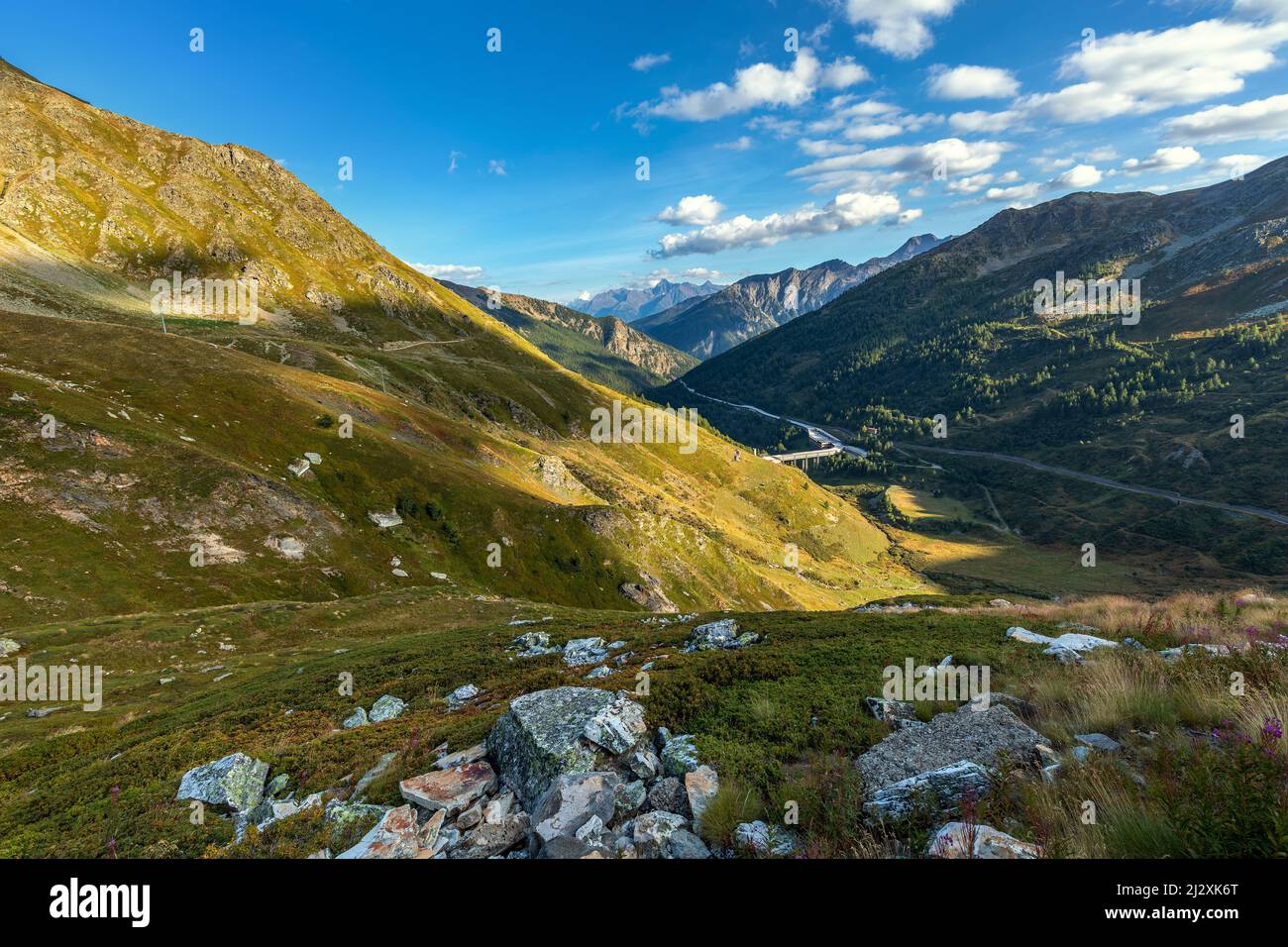 Vista sulle montagne verdi sotto il cielo blu vicino al Passo del Gran San Bernardo in Valle d'Aosta, nel Nord Italia. Foto Stock