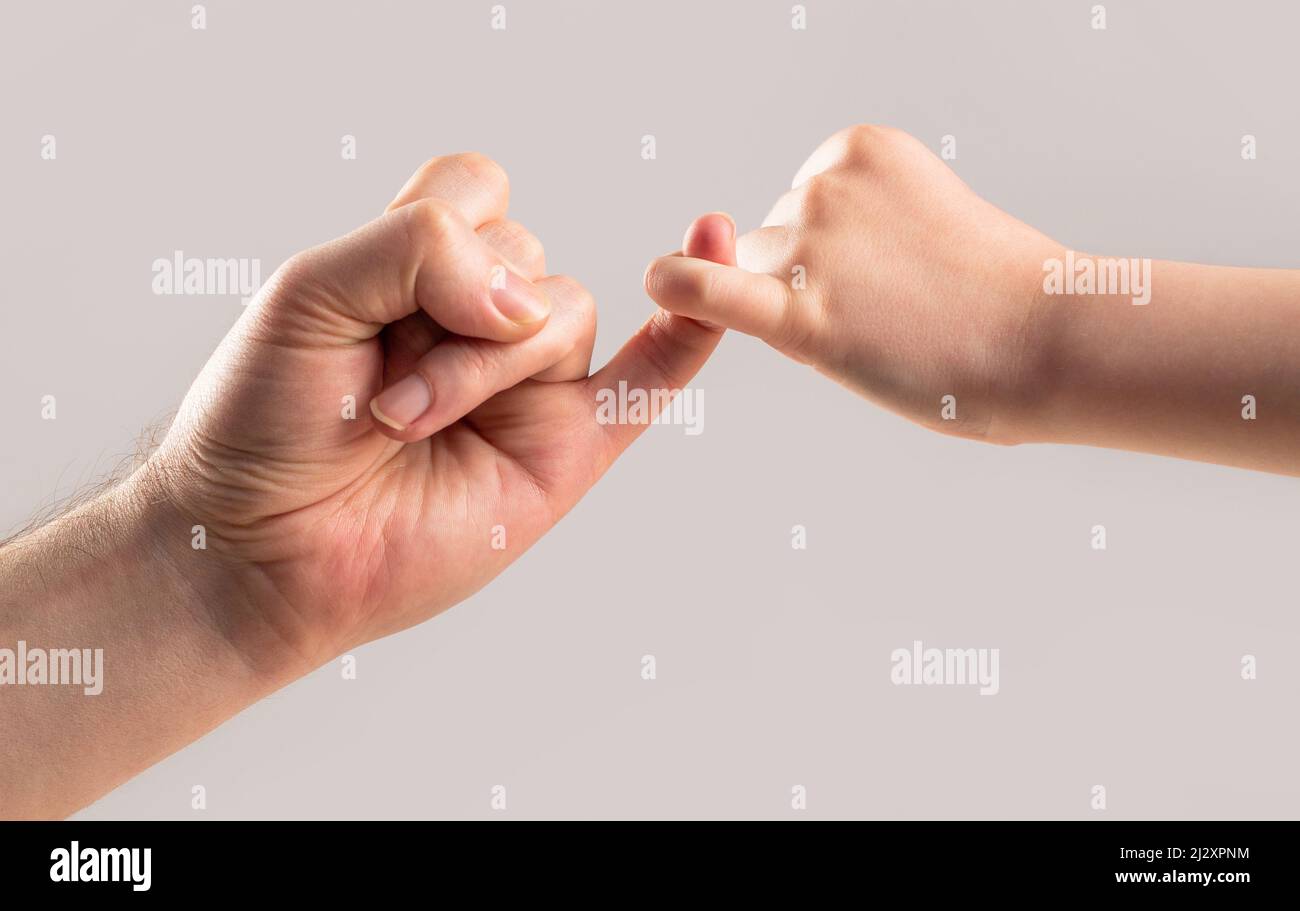 Amicizia di generazioni. Padre, la mano di figlia che fa concetto di amicizia di promessa. I bambini agganciano un dito piccolo insieme. Dito delle due mani Foto Stock