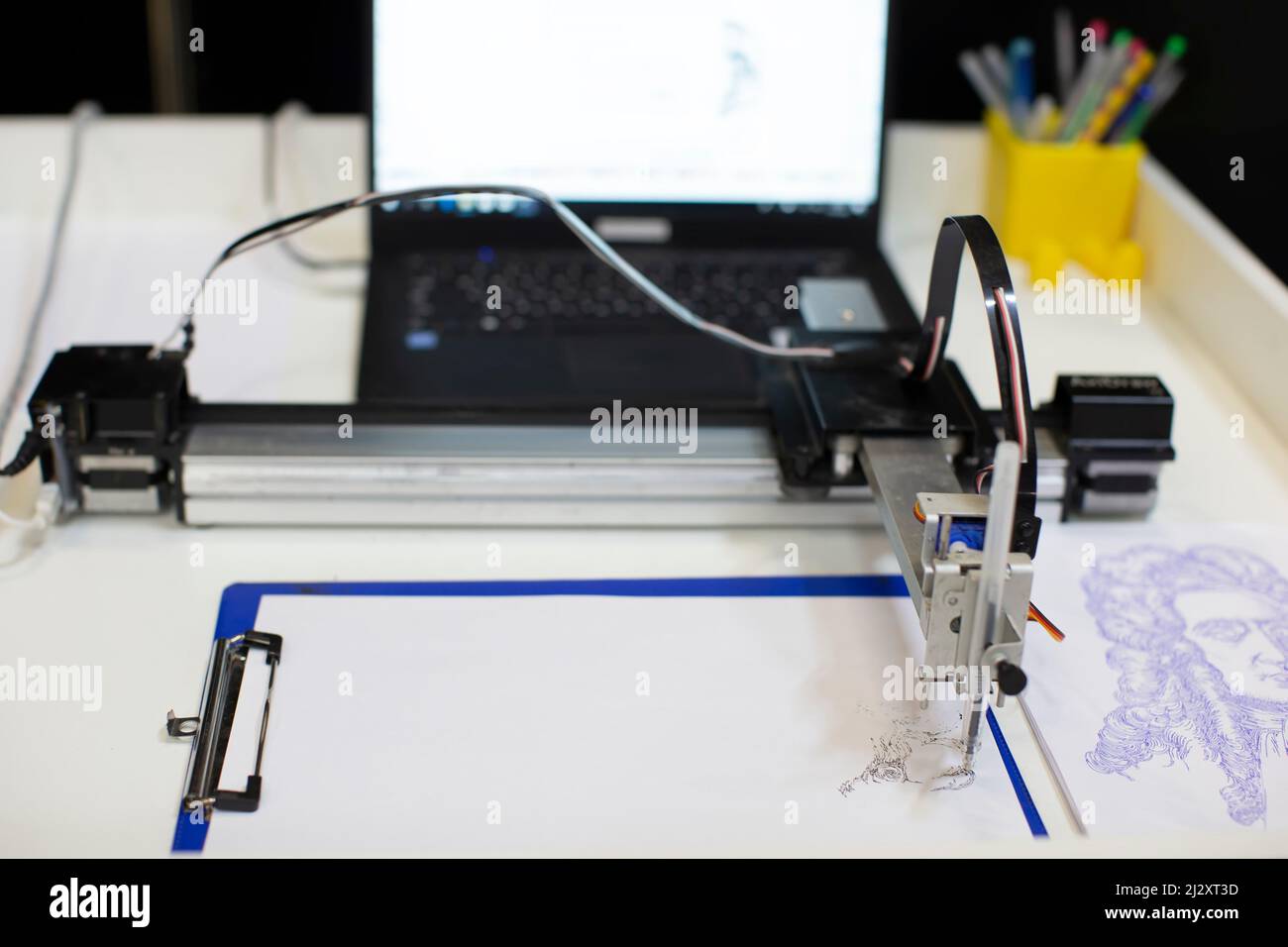 Robot Festival. La mano del robot fa un disegno. La mano del robot con la matita disegna i disegni grafici semplici su whit Foto Stock