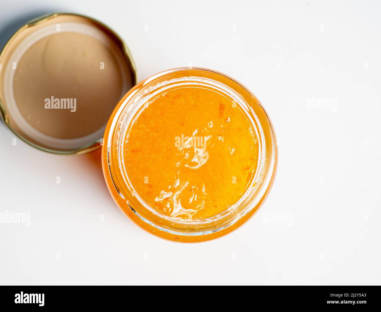 aprire il vaso di marmellata d'arancia con il coperchio su sfondo bianco Foto Stock