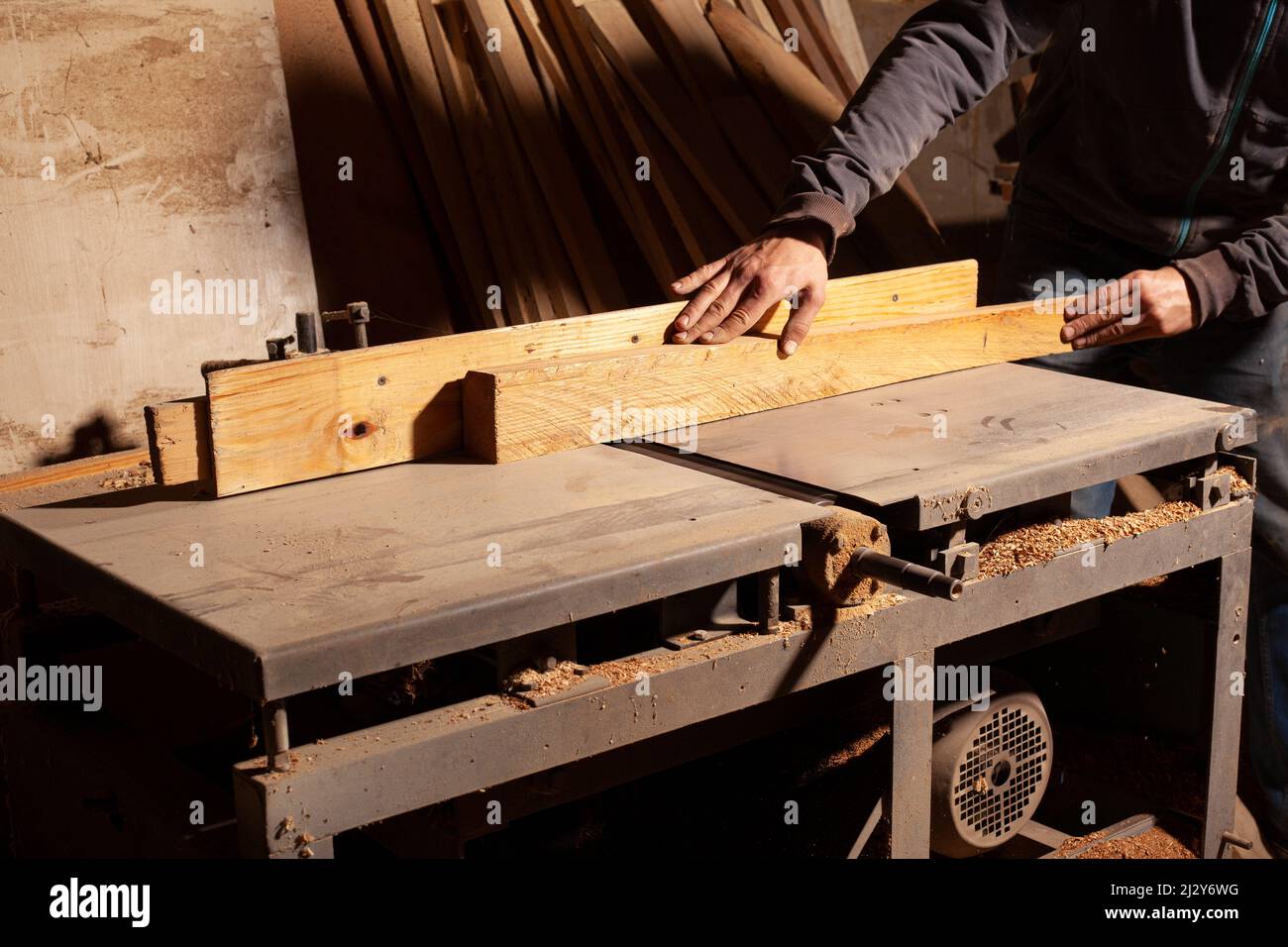 levigare il pannello di legno da falegname su una rettificatrice. Foto Stock
