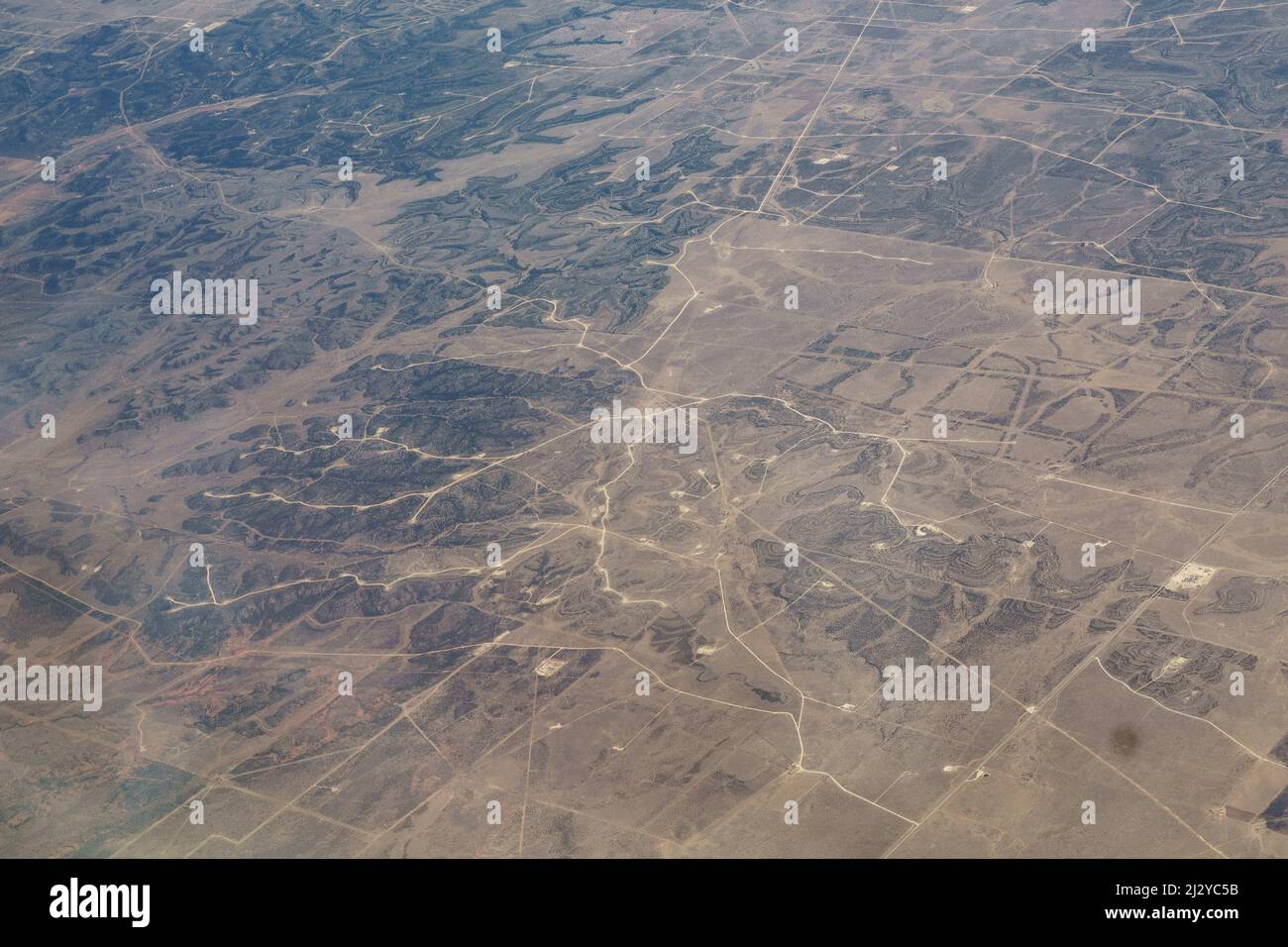 Vista aerea del campo di West Texas gas and Oil Fracking Pads e turbine eoliche, estrazione risorse Texas. Foto Stock