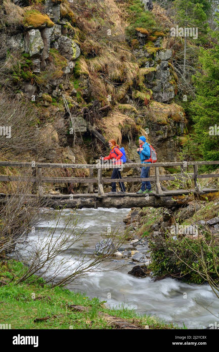 Escursioni uomo e donna sul ponte sul torrente, Donnerschlucht, Nockberge, Nockberge-Trail, Unesco Biosphere Park Nockberge, Gurktal Alpi, Carinzia, Austria Foto Stock