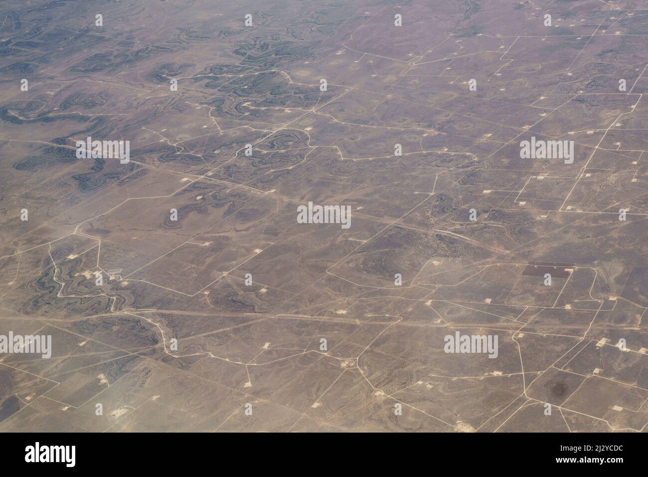 Vista aerea del campo di West Texas gas and Oil Fracking Pads e turbine eoliche, estrazione risorse Texas. Foto Stock